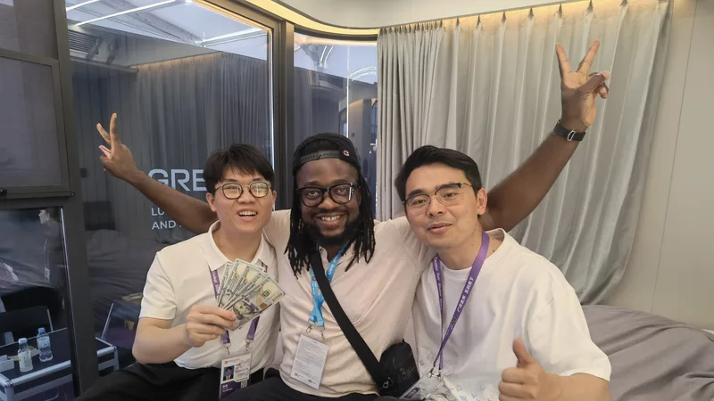 CGCH sales rep, African buyer, and sales manager celebrating a Canton Fair deal inside an Expandable House — cash and V-signs