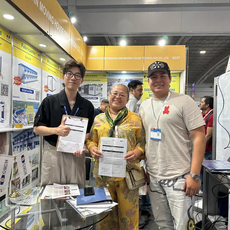 CGCH sales rep with two Mexican buyers holding signed receipts at the Casa Cápsula booth (EXPOMIHN, Mexico)